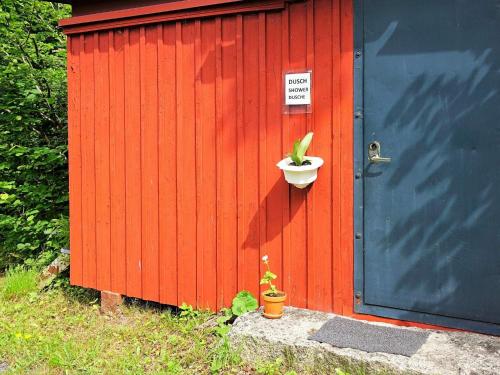 a redshed with a plant in a pot next to a door at 5 person holiday home in TINGSRYD-By Traum in Tingsryd