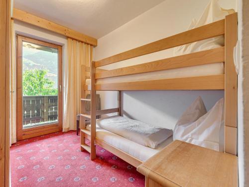 Un dormitorio con dos literas y una ventana. en Apartment in Zillertal near Spieljochbahn, en Fügen
