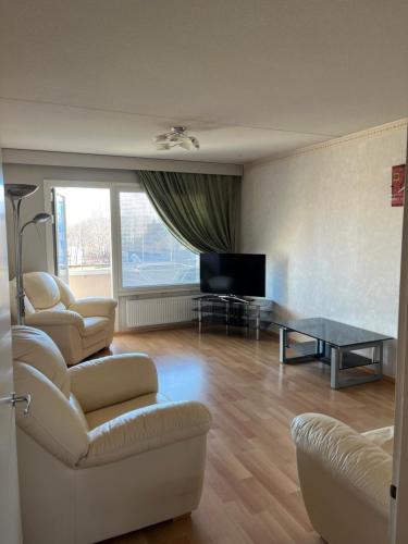 a living room with a couch and a table and a tv at Kolmioasunto Haminassa in Hamina