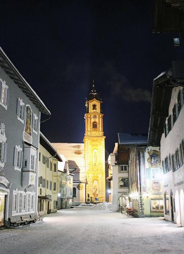a clock tower in the middle of a street at night at Post-Hotel in Mittenwald