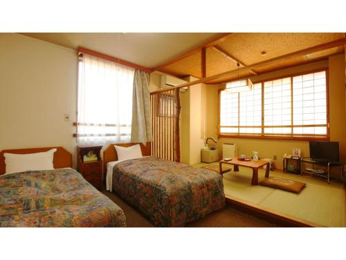 una camera d'albergo con due letti e un tavolo di Hotel Itakura - Vacation STAY 70058v a Fukushima