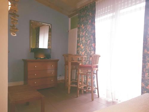 a bedroom with two chairs and a dresser and a mirror at Cafe und Pension am Rennsteig in Blankenstein