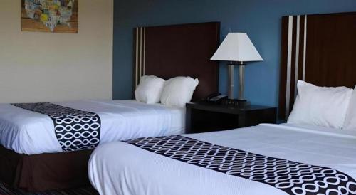 a hotel room with two beds and a lamp at Econo Lodge Inn & Suites in Enid