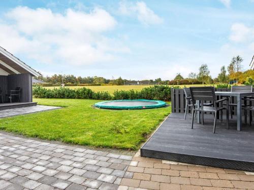 a patio with a table and chairs and a trampoline at Family Retreat in Hovborg - By Traum Ferienwohnungen in Hovborg