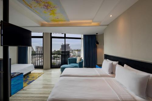 a hotel room with two beds and a balcony at Siam@Siam Design Hotel Pattaya in Pattaya Central