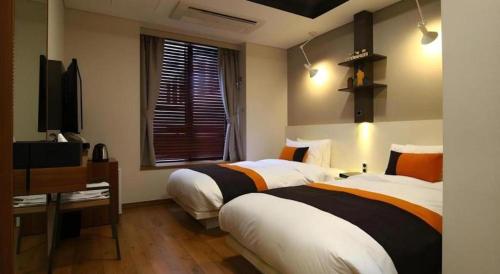 a hotel room with two beds and a television at KT&G Sangsangmadang Chuncheon Stay (Korea Quality) in Chuncheon