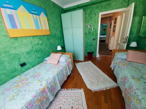 two beds in a room with green walls at B&B Le Ginestre in Collestrada