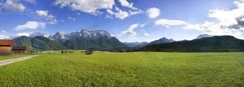 a field of green grass with mountains in the background at Post-Hotel in Mittenwald