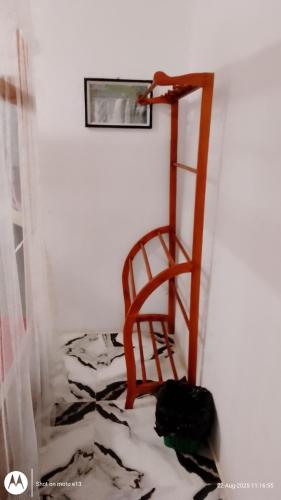 a wooden chair in a room with a floor at Hiriketiya Lima Homestay in Dickwella