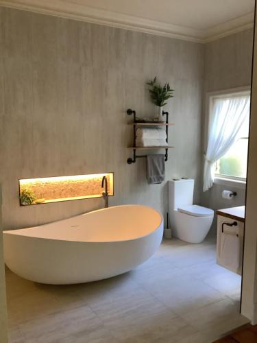 a bathroom with a large tub and a toilet at Pericoe Retreat in Dubbo