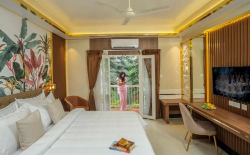 a woman standing at the door of a hotel room at The Grand in Thekkady