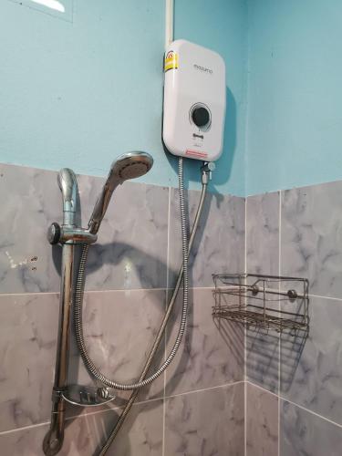 a shower head with a hose attached to a wall at Cozy Apartment Kitchen 1 in Ko Lanta