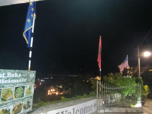 two flags on top of a building at night at Guest House Bake in Gjirokastër