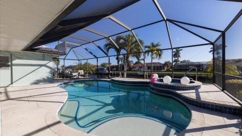 a swimming pool with a large glass walled building at GRH10327 - Charlotte Harbor Area - 3 Bed 2 Baths Villa in Punta Gorda Isles