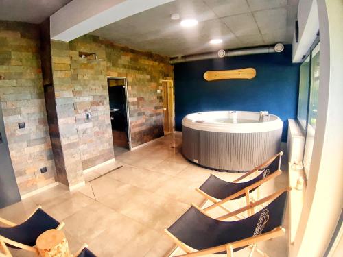 Habitación grande con bañera y sillas. en Apartament w górach ze SPA, en Szczyrk