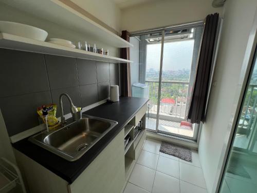 eine Küche mit einem Waschbecken und einem großen Fenster in der Unterkunft Cozy5Living in Bangkok 60m to MRT near chatuchank in Ban Bang Khwang