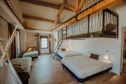 a bedroom with two beds and a loft at Le Mas des vignes - Piscine - Jacuzzi - 18 pers in Cazes-Mondenard