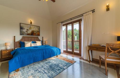 a bedroom with a bed and a desk and a window at Villa Lumi, Villas By Noor in Aldona
