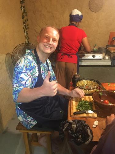a man sitting on a table in a kitchen at Tiny Villa Homestay - Only For Foreign Bookings in Kurunegala