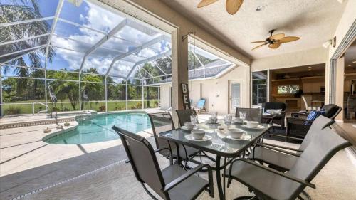 a dining room with a table and chairs and a pool at GRH11408 - Charlotte Harbor Area - 3 Bed 3 Baths Villa in Rotonda