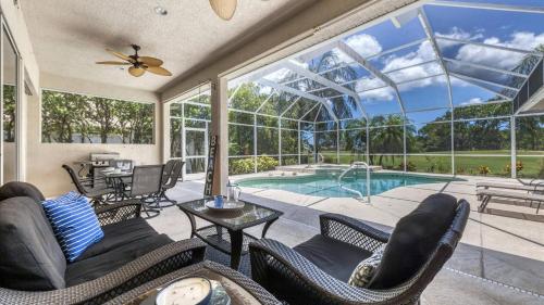 a conservatory with a pool and chairs and a table at GRH11408 - Charlotte Harbor Area - 3 Bed 3 Baths Villa in Rotonda