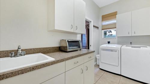 a white kitchen with a sink and a microwave at GRH11408 - Charlotte Harbor Area - 3 Bed 3 Baths Villa in Rotonda