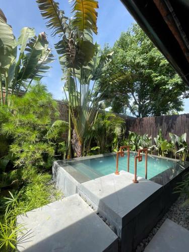 a small swimming pool in a garden with trees at Ancient Huế Garden Houses in Hue