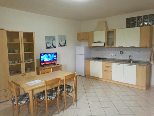 a kitchen with a table and a television in it at Case Sole e Luna in Porto Azzurro