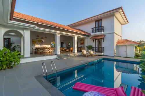 a villa with a swimming pool and a house at Villa Lumi, Villas By Noor in Aldona