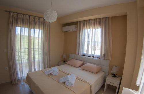 a bedroom with two beds with towels on them at Ianthi Maisonettes in Nea Roda