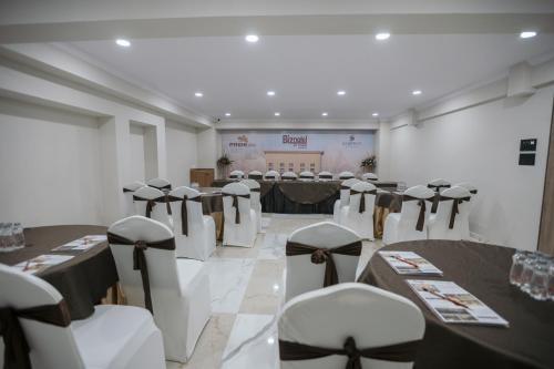 a room with rows of tables and chairs in it at Biznotel by Pride Surat in Surat