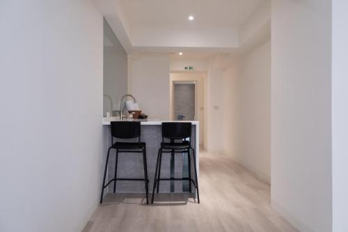 a kitchen with two bar stools at a kitchen counter at 芭驛 8hundredmillion I 安平運河景觀住宿 in Anping