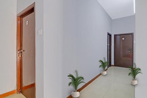un pasillo con dos macetas y una puerta en Hotel O FOURTEEN, en Kondapur