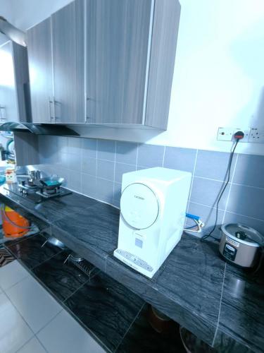a white appliance on a counter in a kitchen at Homestay Annur Impian Temerloh With WIFI & NEXFLIX in Temerloh