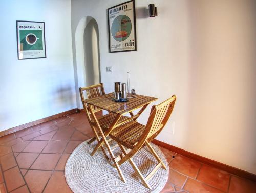 a wooden table and two chairs in a room at Villa Verde splendida villa con piscina - Stintino Sardegna in Cuile Pazzoni