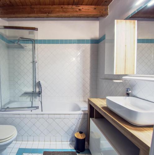 a bathroom with a sink and a tub and a toilet at Villa Verde splendida villa con piscina - Stintino Sardegna in Cuile Pazzoni