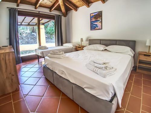 a bedroom with a large bed with towels on it at Villa Verde splendida villa con piscina - Stintino Sardegna in Cuile Pazzoni