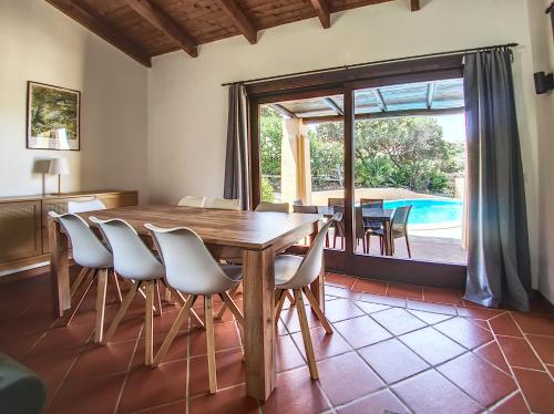 a dining room with a table and chairs and a pool at Villa Verde splendida villa con piscina - Stintino Sardegna in Cuile Pazzoni