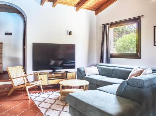 a living room with a couch and a tv at Villa Verde splendida villa con piscina - Stintino Sardegna in Cuile Pazzoni