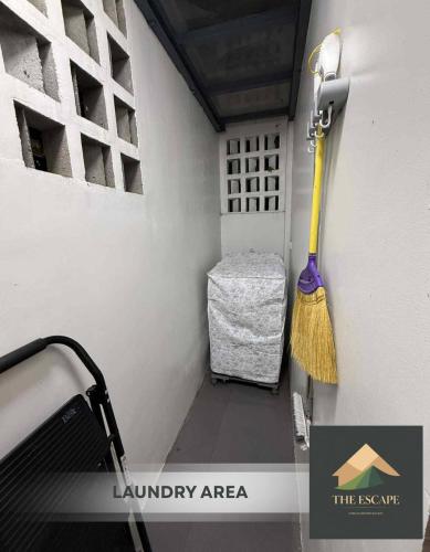 a laundry area with a broom and a bench at The Escape - Malolos in Mujon