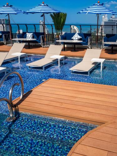 a pool with chairs and umbrellas on a cruise ship at Siam@Siam Design Hotel Pattaya in Pattaya Central