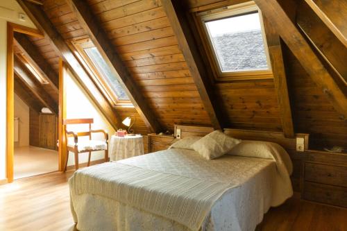 ein Schlafzimmer mit einem Bett in einem Holzhaus in der Unterkunft Hostal Aiguamog in Salardú