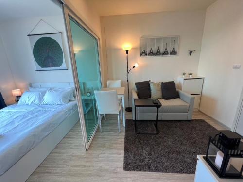 ein Schlafzimmer mit einem Spiegel, einem Bett und einem Stuhl in der Unterkunft Cozy9Living in Bangkok 60mto MRT in Ban Bang Khwang