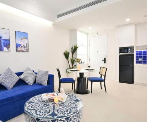 a living room with a blue couch and a table at Hillside residence Phu Quoc, sea &firework view in Phu Quoc