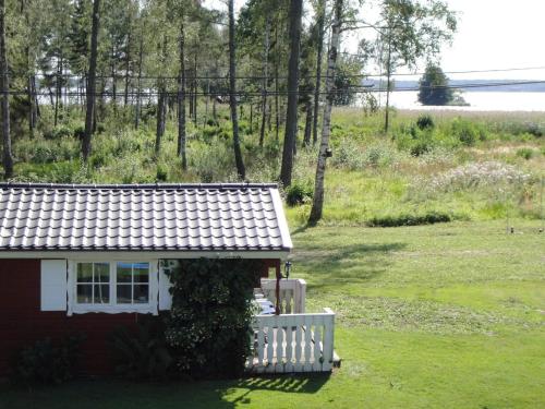 a small house with a white fence next to a field at 6 person holiday home in GLANSHAMMAR-By Traum in Glanshammar