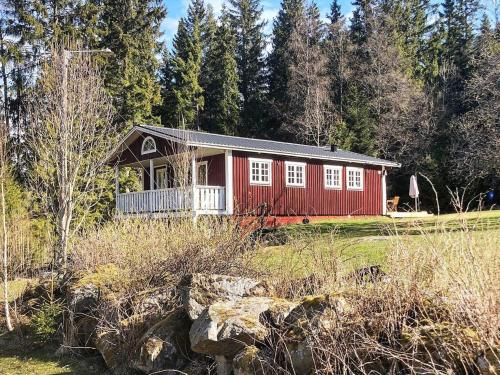 a red house in the middle of a field at 6 person holiday home in SÄVSJÖ in Nykulla