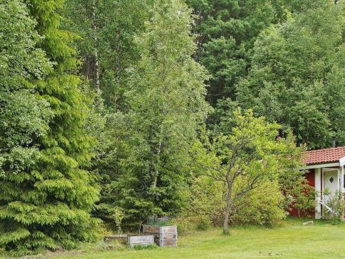 a house in the middle of a yard with trees at 6 person holiday home in SÄVSJÖ in Nykulla