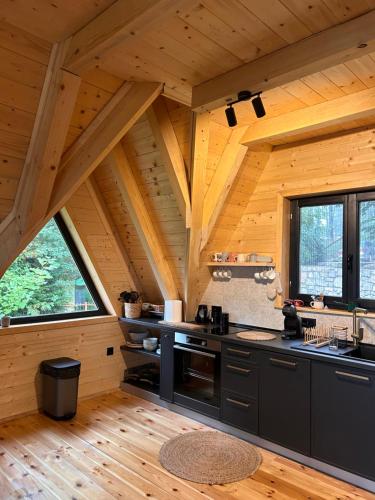 a kitchen in a log cabin with wooden ceilings at Molika Forest House in Kolašin