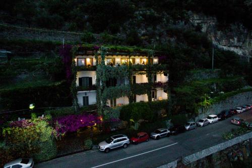 a building with cars parked on the side of a road at Hotel Pellegrino in Praiano
