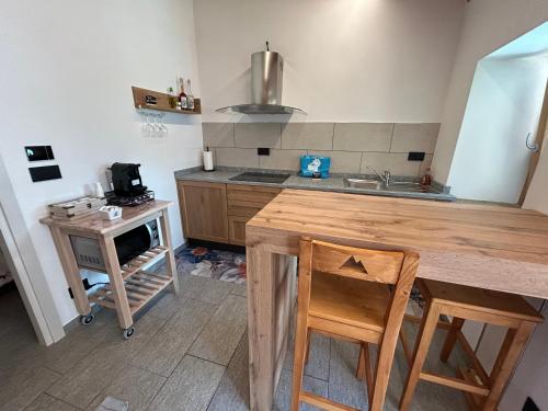 a kitchen with a wooden table and a sink at BAITA GHITIN in Ostana